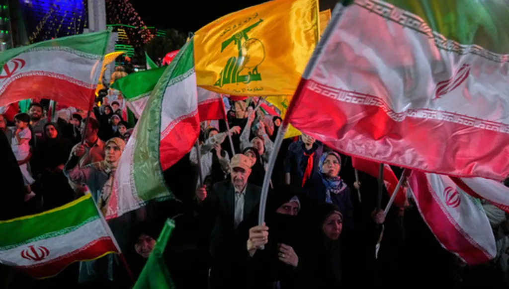 Pro-government Iranian demonstrators wave their country's flags and Lebanon's militant Hezbollah group flags in a gathering in Tehran, Iran, Sunday, June 7, 2026. (AP Photo/Vahid Salemi)