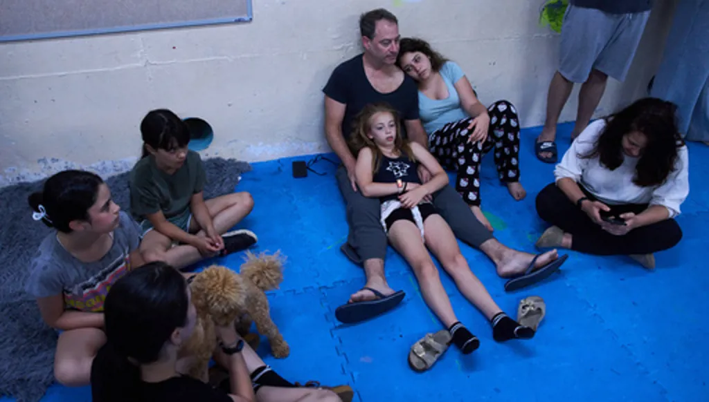 People take shelter as air raid sirens warn of incoming Iranian missiles in Ramat Gan, Israel, Monday, June 8, 2026. (AP Photo/Oded Balilty)