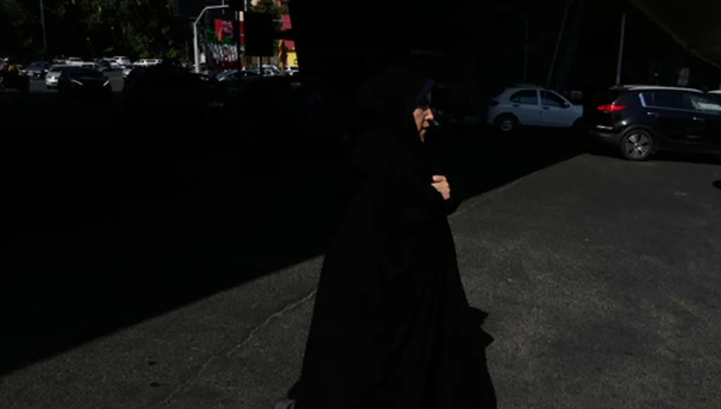 A woman crosses an intersection in northern Tehran, Wednesday, June 10, 2026. (AP Photo/Vahid Salemi)