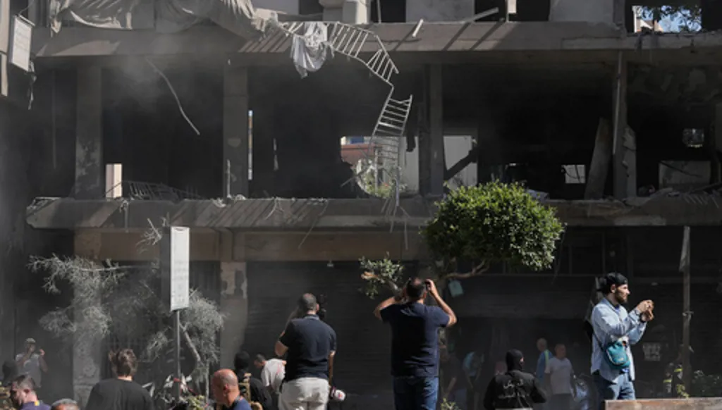 People gather at the site of an Israeli airstrike that struck an apartment in Dahiyeh, Beirut's southern suburbs, Lebanon, Sunday, June 14, 2026. (AP Photo/Bilal Hussein)