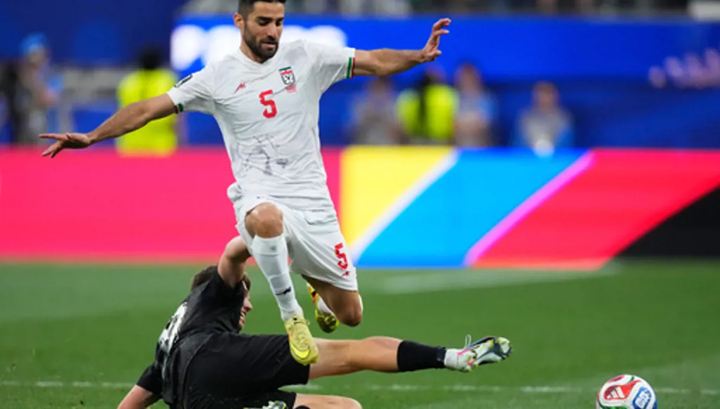 Iran's Milad Mohammadi (5) jumps over New Zealand's Callum McCowatt (20) during the World Cup Group G soccer match between Iran and New Zealand in Inglewood, Calif., near Los Angeles, Monday, June 15, 2026. (AP Photo/Mark J. Terrill)