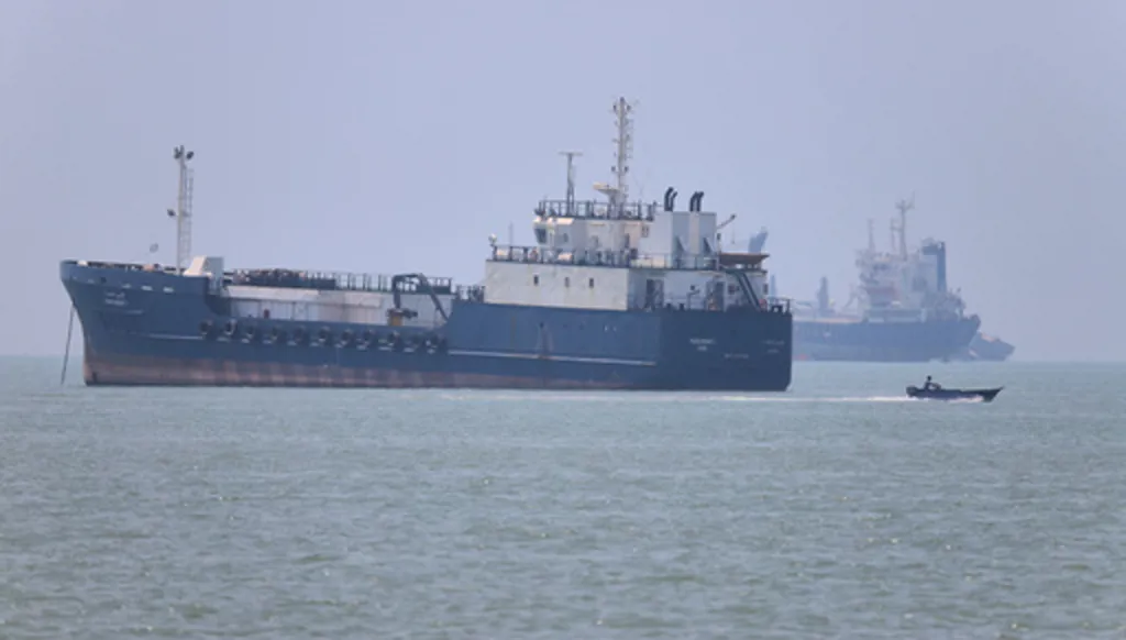A small motorboat passes anchored vessels in the Strait of Hormuz off Bandar Abbas, Iran, Wednesday, June 17, 2026.(Amirhosein Khorgooi/ISNA via AP)