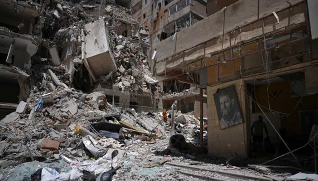 Barber Wissam Srour, 41, right, searches for belongings in the rubble of his barbershop, damaged in an Israeli strike, in the southern port city of Tyre, Lebanon, Friday, June 19, 2026. (AP Photo/Hassan Ammar)