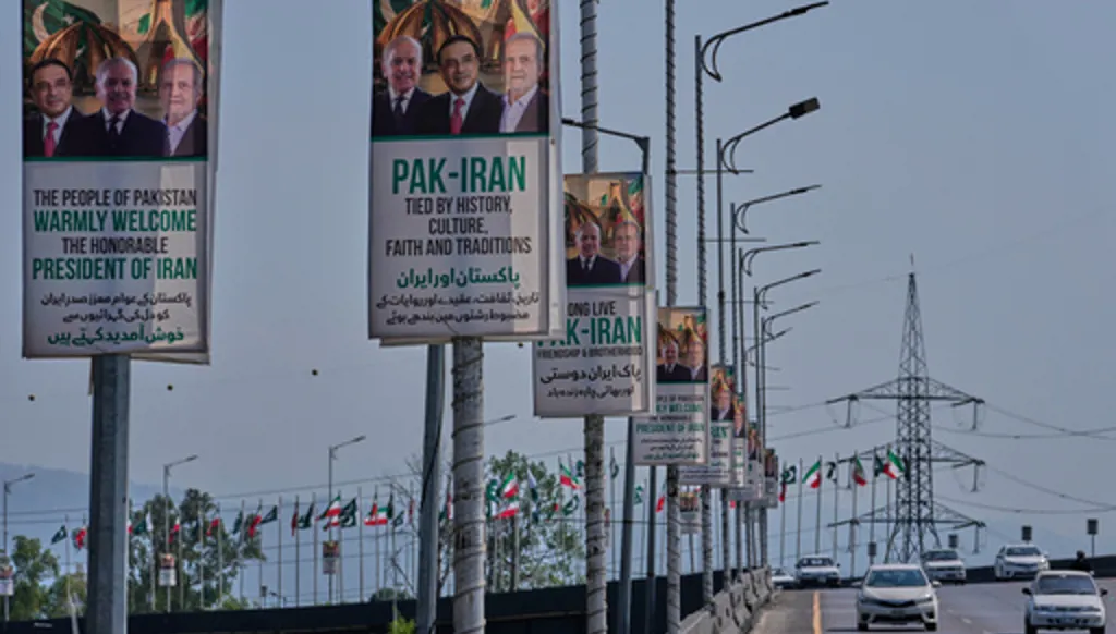 Vehicles drives past welcoming billboards featuring Iranian President Masoud Pezeshkian, right, with Pakistan President Asif Ali Zardari, center, and Shehbaz Sharif alongside an overhead bridge in Islamabad, Pakistan, Tuesday, June 23, 2026. (AP Photo/Anjum Naveed)