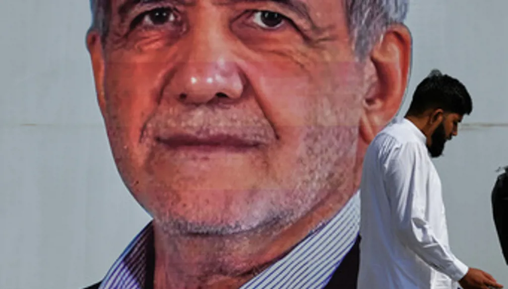 A man walks past a welcoming billboard featuring Iranian President Masoud Pezeshkian along a roadside in Islamabad, Pakistan, Tuesday, June 23, 2026. (AP Photo/Anjum Naveed)