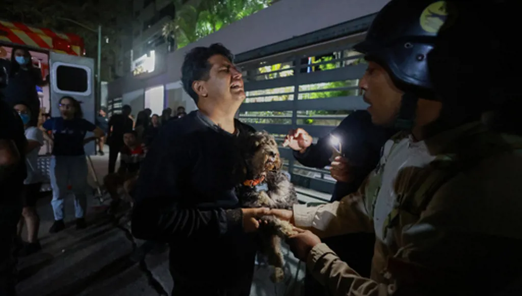 A man holding a dog cries after an earthquake in Caracas, Venezuela, Wednesday, June 24, 2026. (AP Photo/Javier Campos)
