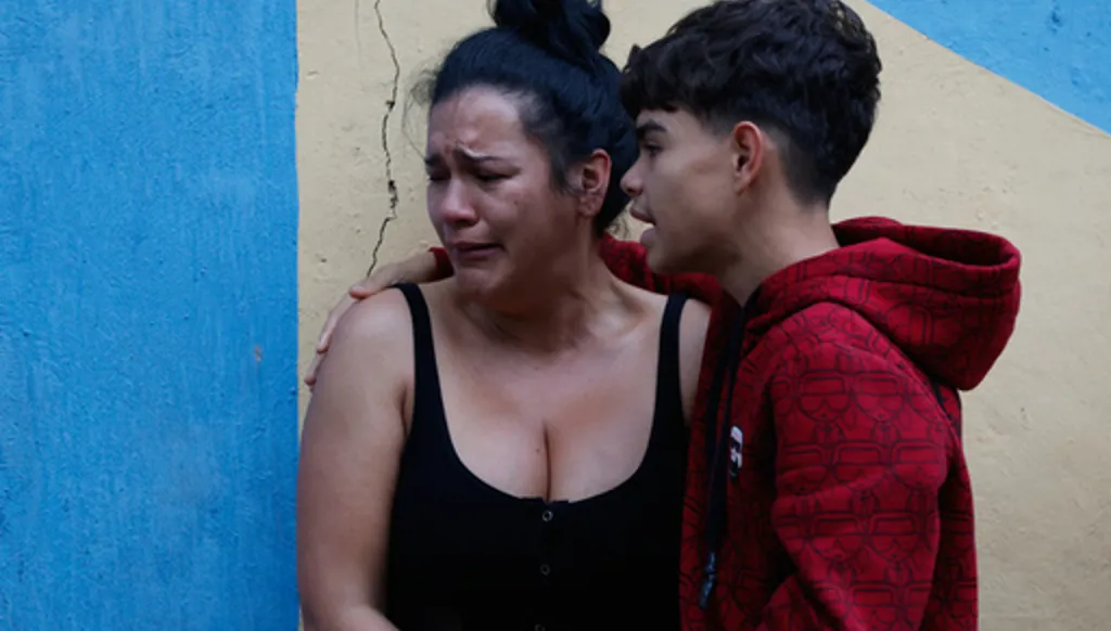 A boy comforts his mother after an earthquake in Caracas, Venezuela, Wednesday, June 24, 2026. (AP Photo/Pedro Mattey)