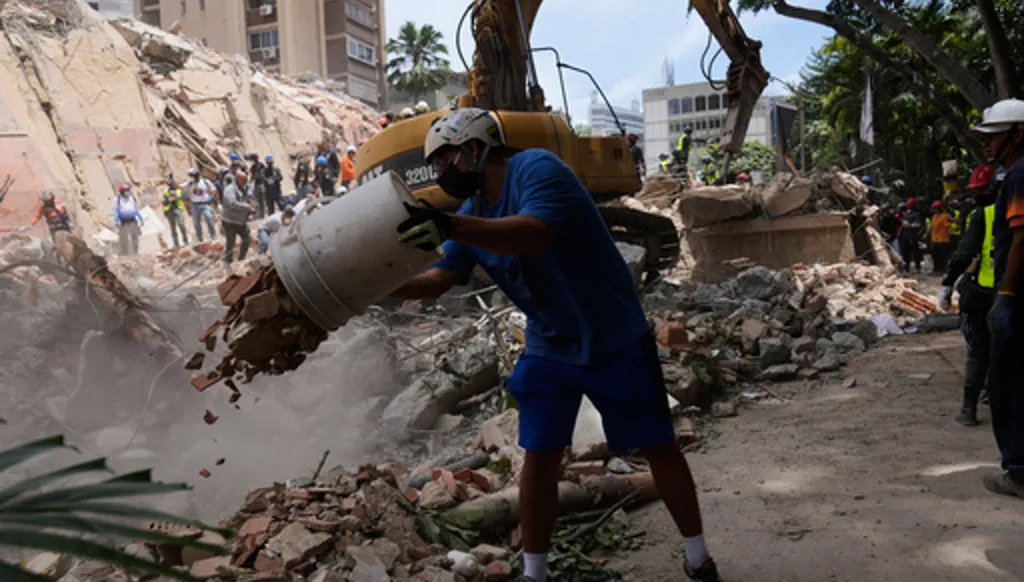 Residents help to remove rubble from a collapsed building in Caracas, Venezuela, Thursday, June 25, 2026, a day after successive powerful earthquakes struck the country. (AP Photo/Ariana Cubillos)