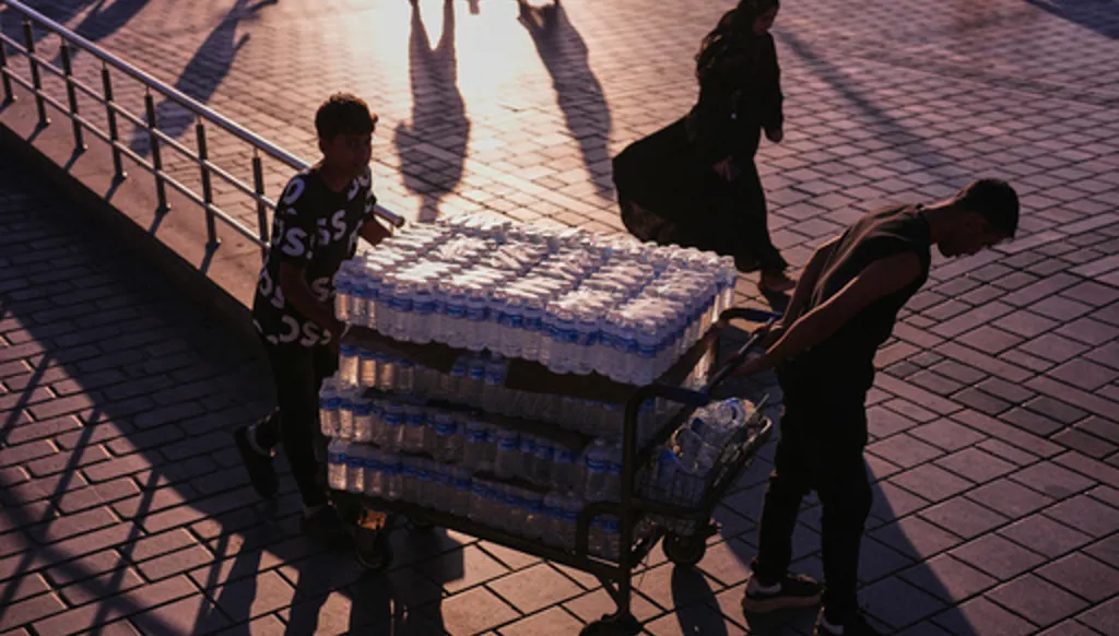 Workers deliver water bottles to a restaurant next to Galata bridge on a summer day in Istanbul, Turkey, Friday, June 26, 2026. (AP Photo/Francisco Seco)