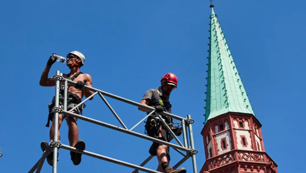 A worker drinks water as he sets up a stage for the upcoming Ironman triathlon, Frankfurt, Germany, Thursday, June 25, 2026. (AP Photo/Michael Probst)