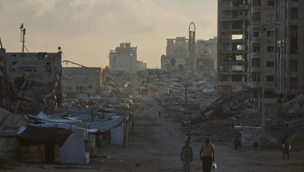 Palestinians walk along a street surrounded by buildings destroyed in Israeli military strikes during the Israel-Hamas war, in Gaza City, Thursday, July 2, 2026. (AP Photo/Jehad Alshrafi)
