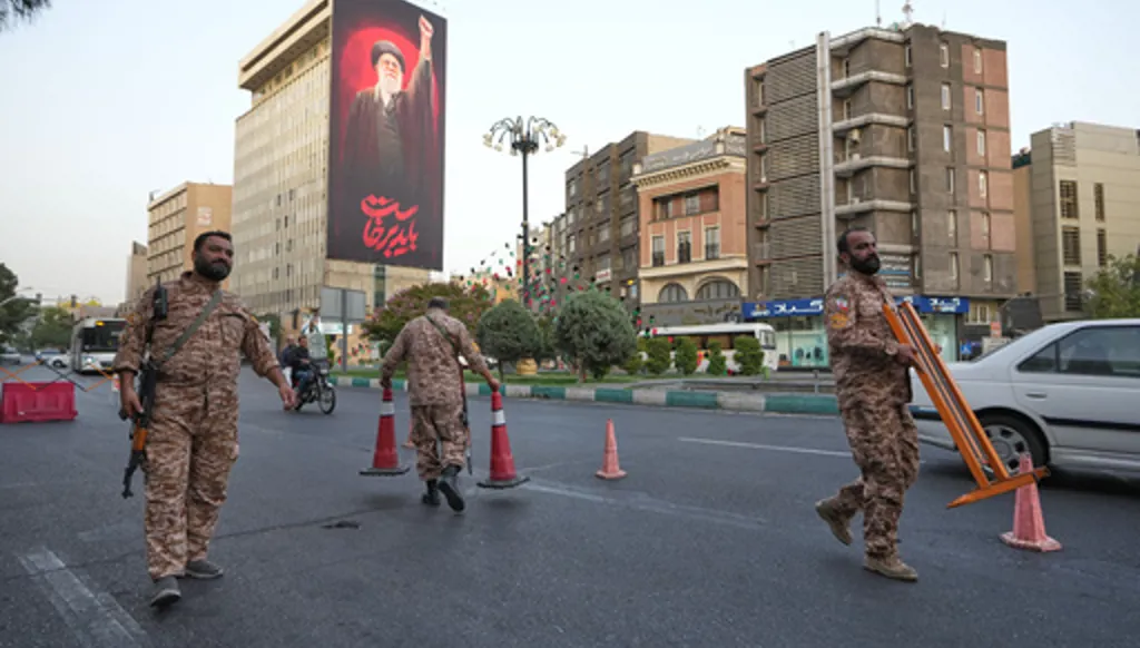 Iran's Basij paramilitary forces set up a checkpoint at a square ahead of the funeral ceremonies of slain Supreme Leader Ayatollah Ali Khamenei, shown at the billboard at rear, in Tehran, Iran, Thursday, July 2, 2026. (AP Photo/Vahid Salemi)