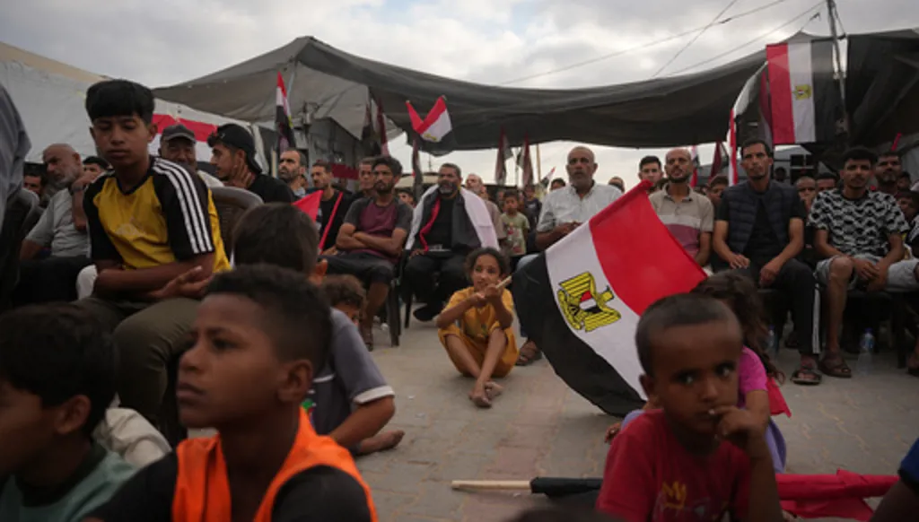 Palestinians watch a live broadcast of the World Cup soccer match between Egypt and Iran on a screen in Nuseirat, central Gaza Strip, Saturday, June 27, 2026. (AP Photo/Abdel Kareem Hana)