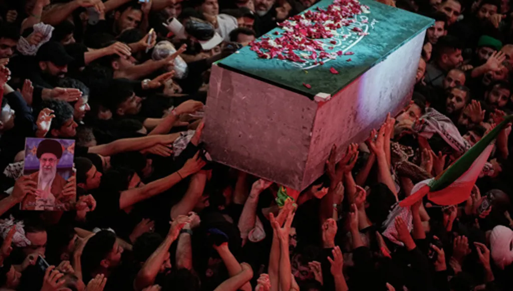 The flower petal-covered coffin of the late Iranian Supreme Leader Ayatollah Ali Khamenei is carried above mourners reaching out to touch it outside the Imam Hussein Shrine in Karbala, Iraq, early Thursday, July 9, 2026. (AP Photo/Khalil Hamra)