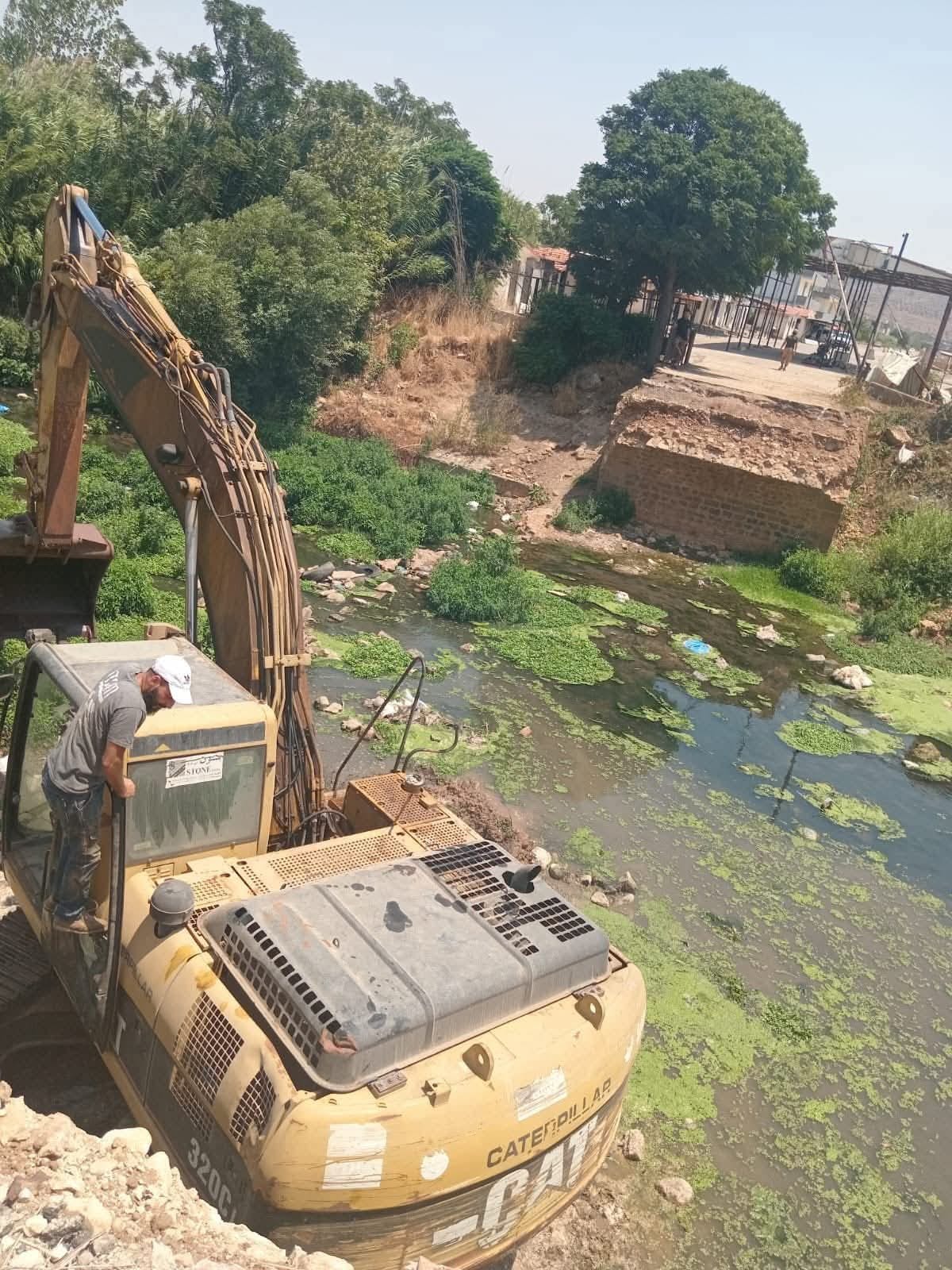 جرافة تعمل لتوسيع مجرى المياه.