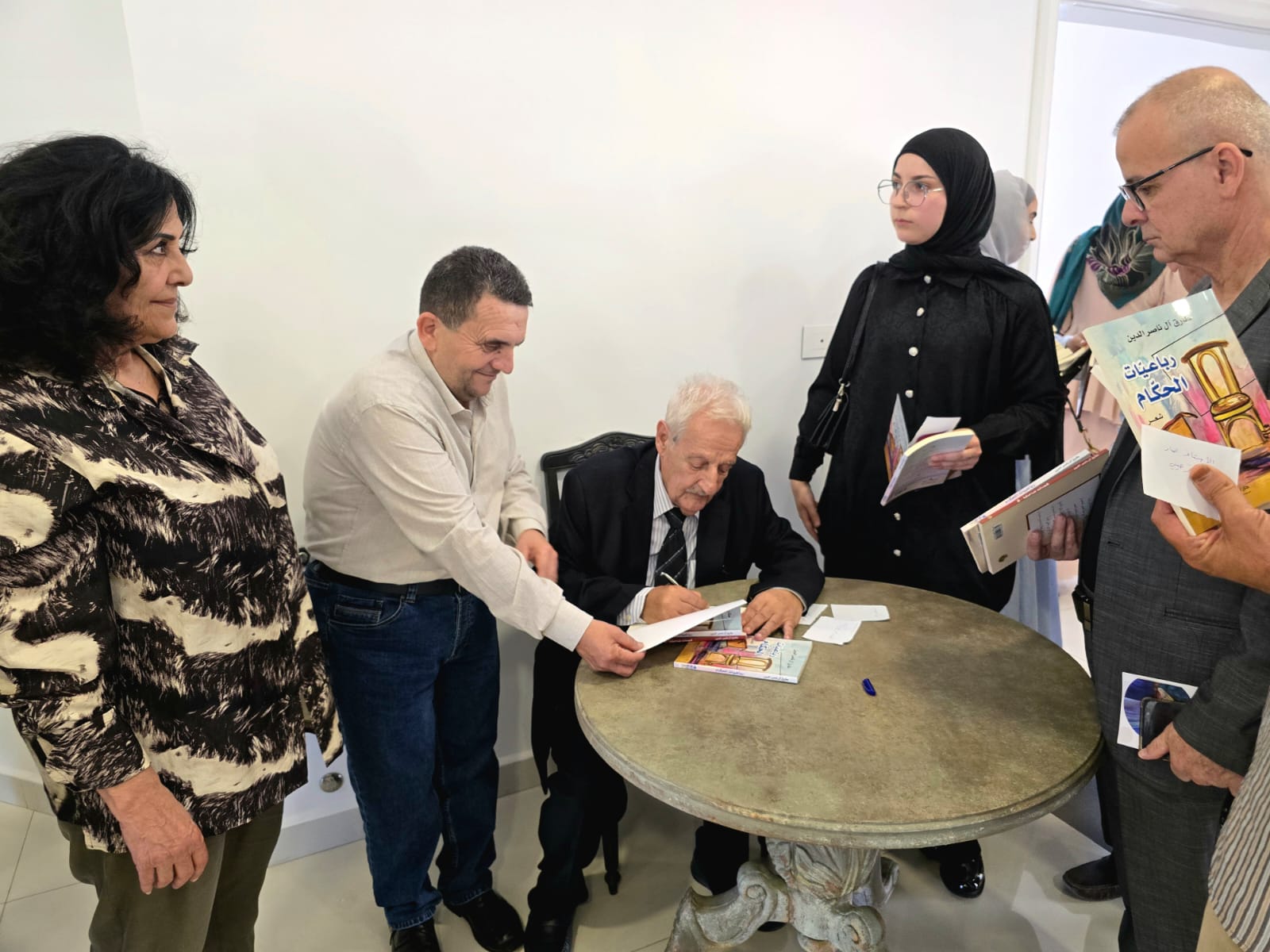 الشاعر آل ناصر الدين يوقع ديوانه.