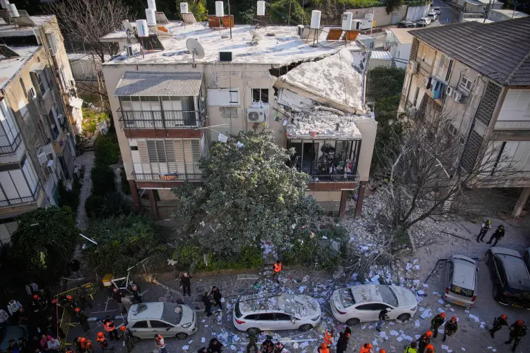 Des officiers du Commandement de l'Arrière d'Israël inspectent un immeuble d'appartements endommagé après une frappe de missile iranienne à Ramat Gan, Israël. (AP)