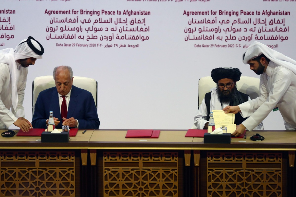 المبعوث الأميركي زلماي خليل زاد والقيادي في طالبان عبد الغني برادر خلال توقيع اتفاق الدوحة بين الولايات المتحدة والحركة، في 29 شباط/فبراير 2020. (وزارة الخارجية الأميركية)
