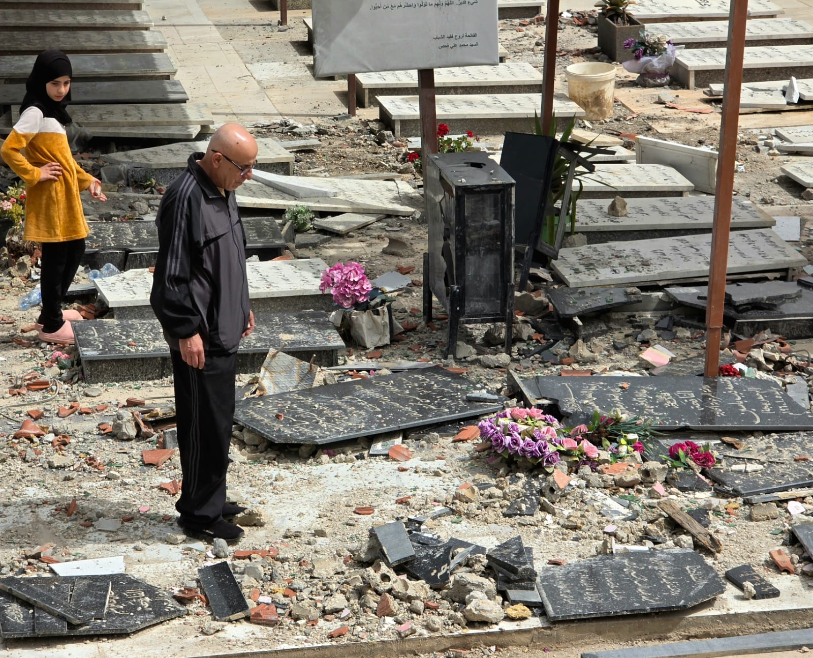 يتلو الصلاة في جبانة لم تسلم من القصف.