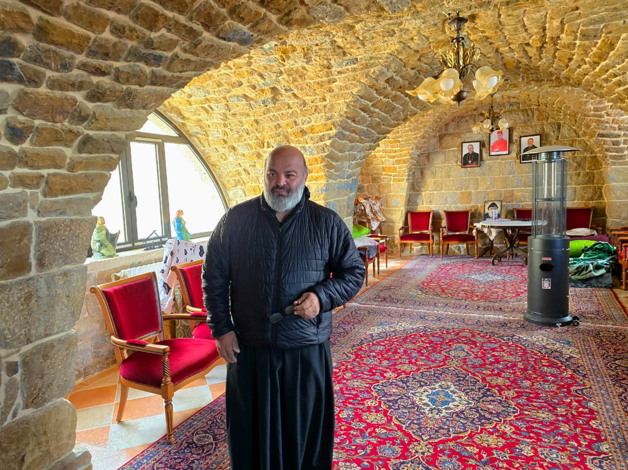 الأب عاقوري في صالون الدير الذي تحول مكان منامة. (أحمد منتش)