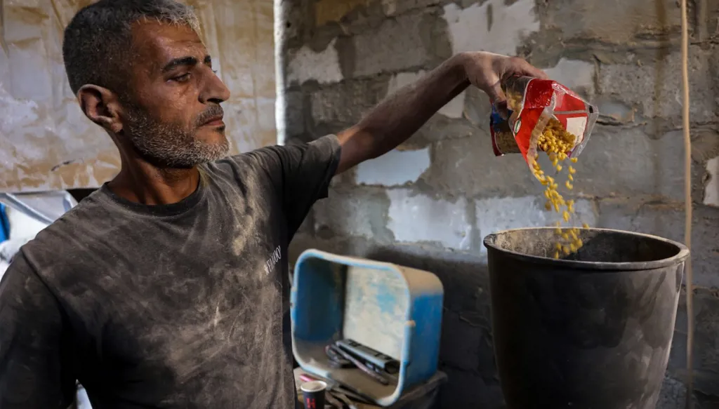 وضع المعكرونة في مطحنة لاستعمالها في صنع الخبز بمخيم جباليا (أ ‏ف ب)‏