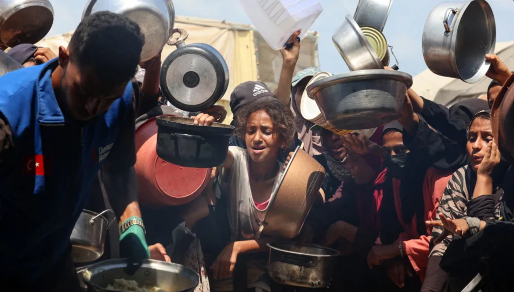 فلسطينيون يتهافتون على الطعام (أ ف ب)