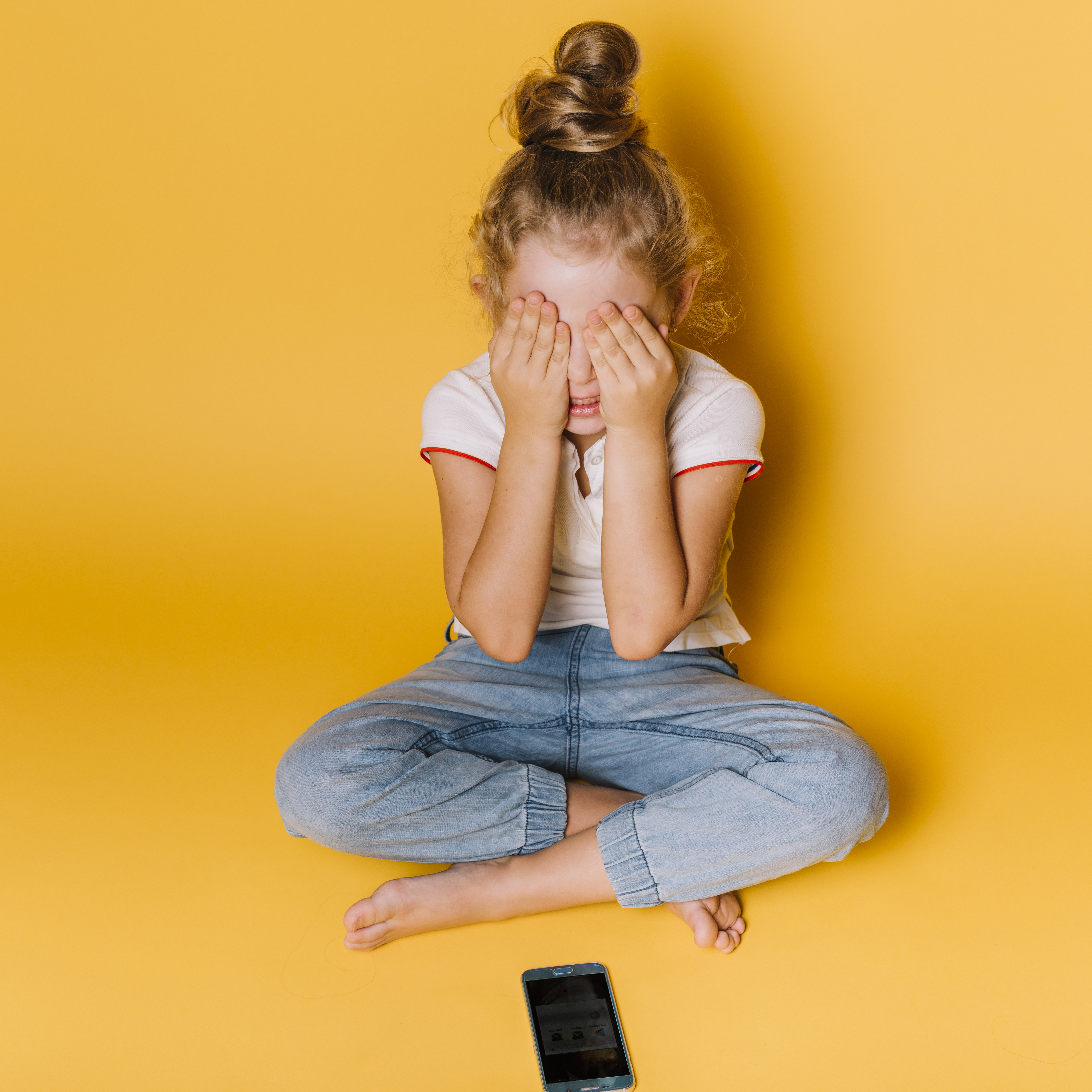 طفلة صغيرة تستخدم الهاتف الذكي (Freepik).