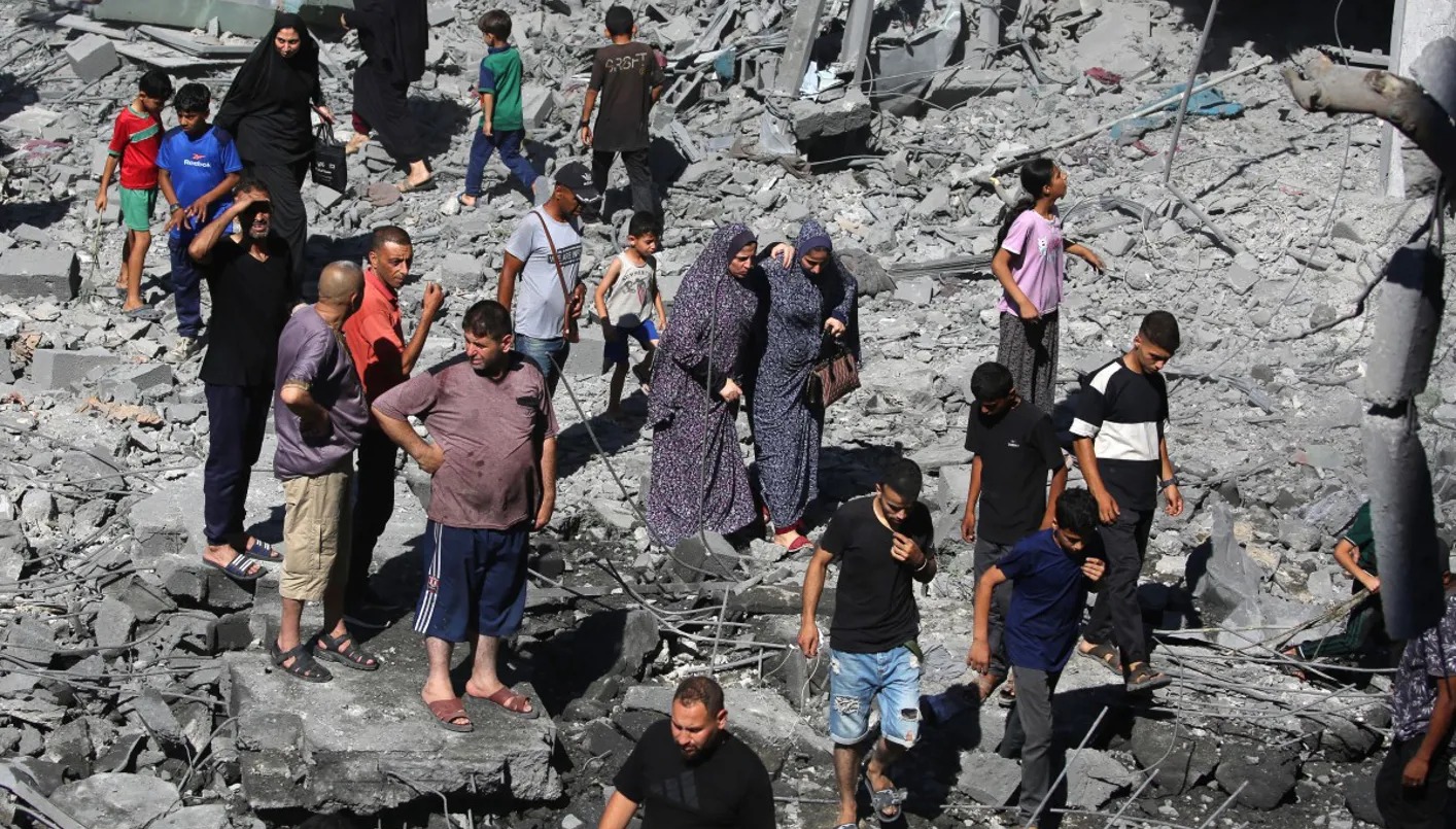 فلسطينيون يتفقدون الأضرار التي لحقت بمخيم البريج وسط قطاع غزة بعد غارة إسرائيلية (أ ف ب).