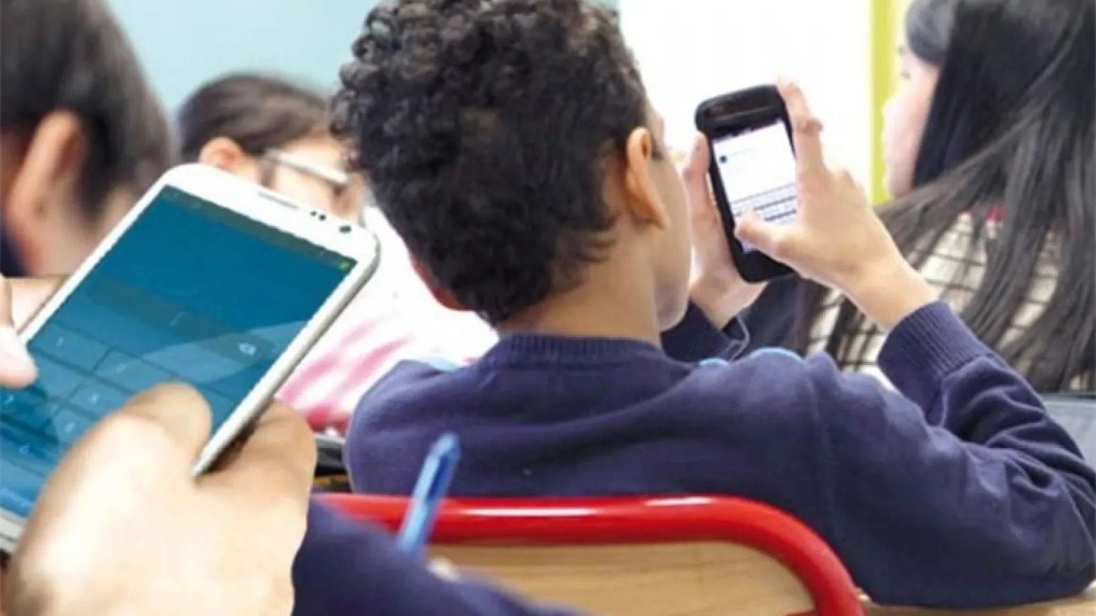 طلاب يحملون هواتف ذكية داخل الصف (انترنت).