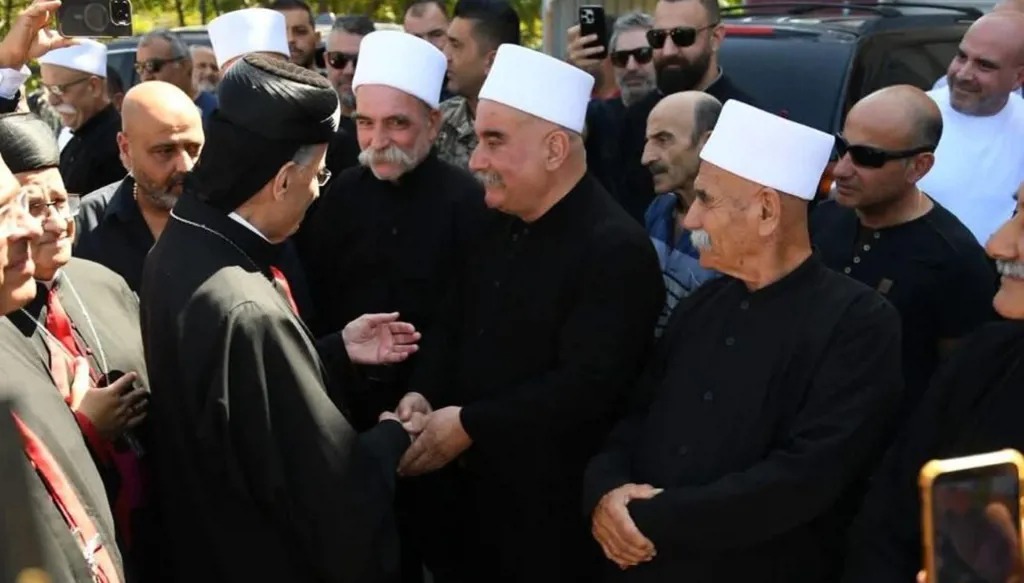 البطريرك بشارة الراعي يصافح مستقبليه من مشايخ دروز وشخصيات لدى وصوله إلى بلدة إبل السقي في جولته الجنوبية أمس.