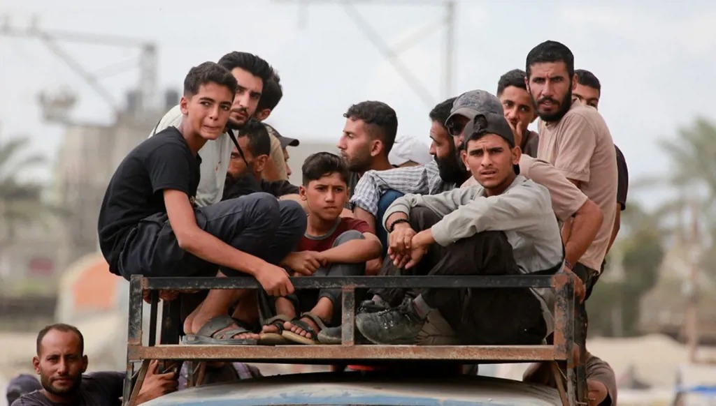 فلسطينيون نازحون يركبون على سطح سيارة في جنوب دير البلح في وسط قطاع غزة (أ ف ب)
