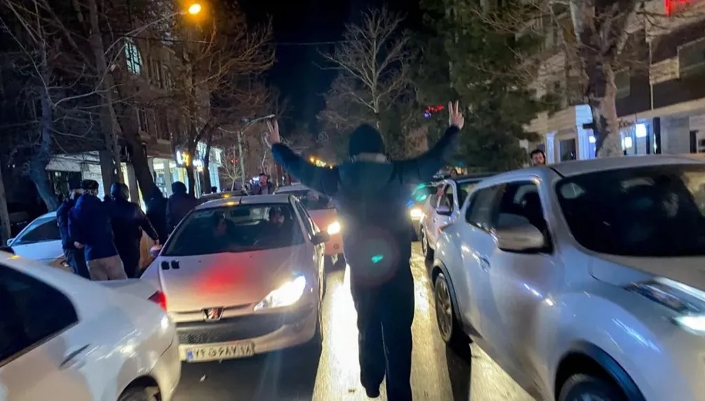 متظاهر إيراني يرفع شاراتي النصر خلال تظاهرات في همدان، إيران، في الأول من يناير. (أ ف ب)