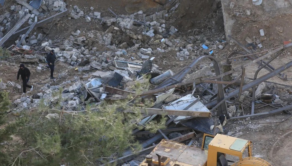 لبنانيون يتفقدون الموقع بعد غارة جوية إسرائيلية استهدفت مبنى في قرية كفر دونين جنوب لبنان. (أ ف ب)