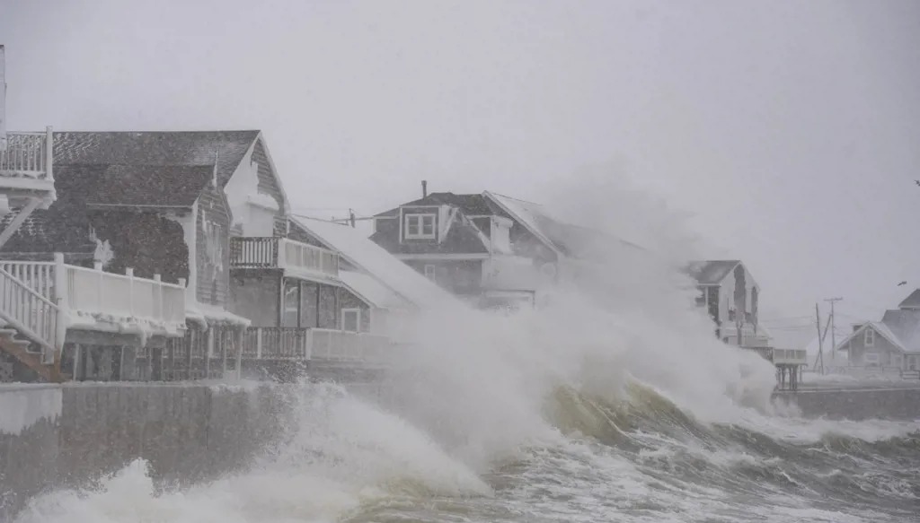 أمواج عالية تضرب المنازل على الشاطئ في سيتوات، ماساتشوستس. (أ ف ب)