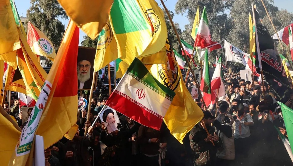 متظاهرون يحرقون أعلام أميركا وإسرائيل أمام السفارة الإيرانية في بغداد، دعماً لطهران، 16 كانون الثاني 2026. (أ ف ب)