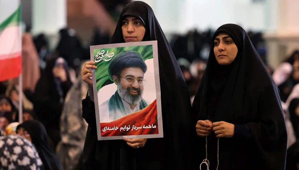 إيرانية تحمل صورة المرشد الأعلى الإيراني آية الله مجتبى خامنئي خلال صلاة عيد الفطر طهران. (ا ف ب).