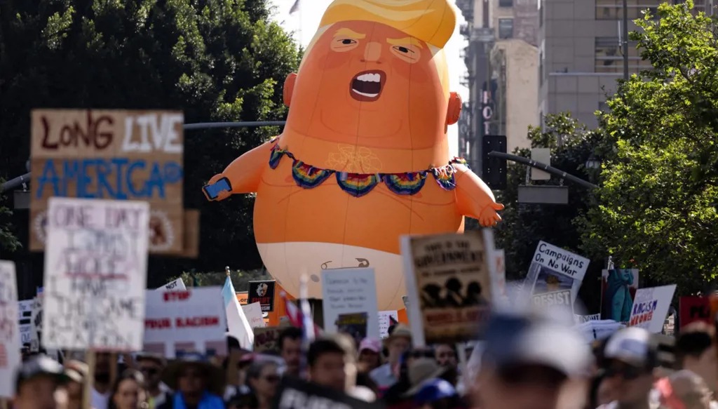 متظاهرون في لوس أنجلس يحملون بالوناً عملاقاً للسخرية من ترامب خلال احتجاجات لا ملوك. (أ ف ب)