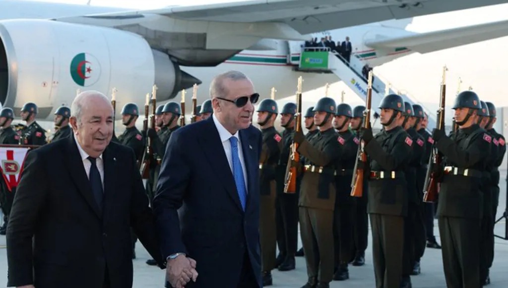 إردوغان مستقبلاً تبون على أرض المطار.
