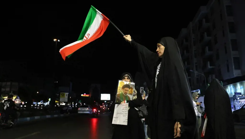 سيدة ترفع العلم الإيراني في طهران (أ ف ب).