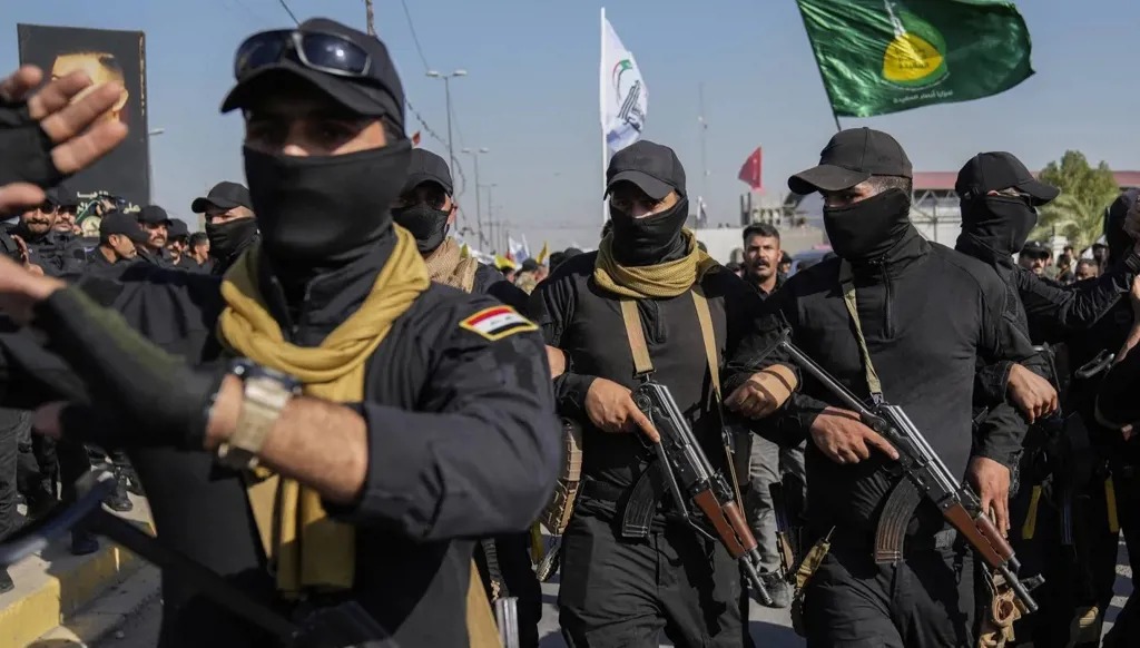عناصر فصيل عراقي مسلح في تشييع رفاق لهم قضوا في ضربة أميركية ببابل. (أسوشيتد برس)