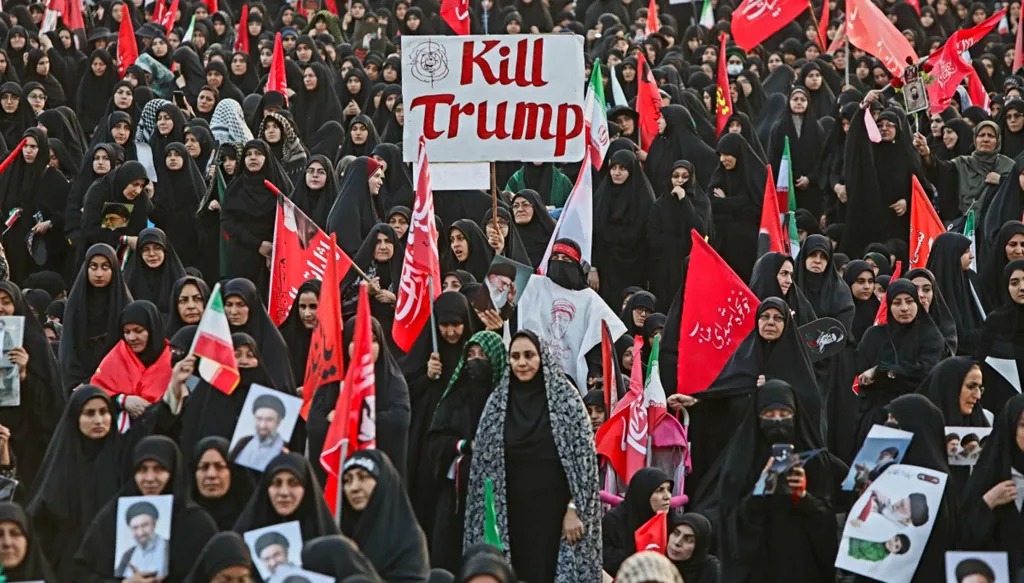 سيدات يحملن لافتة تدعو قتل من الرئيس الأميركي دونالد ترامب خلال مراسم تشييع خامنئي في قم. (أ ف ب)