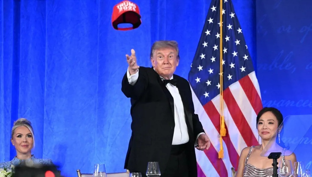 الرئيس الأميركي دونالد ترامب يرمي قبعة تحمل شعار Trump 2028 خلال عشاء رابطة مراسلي البيت الأبيض في واشنطن، 24 تموز/يوليو 2026. (أ ف ب)