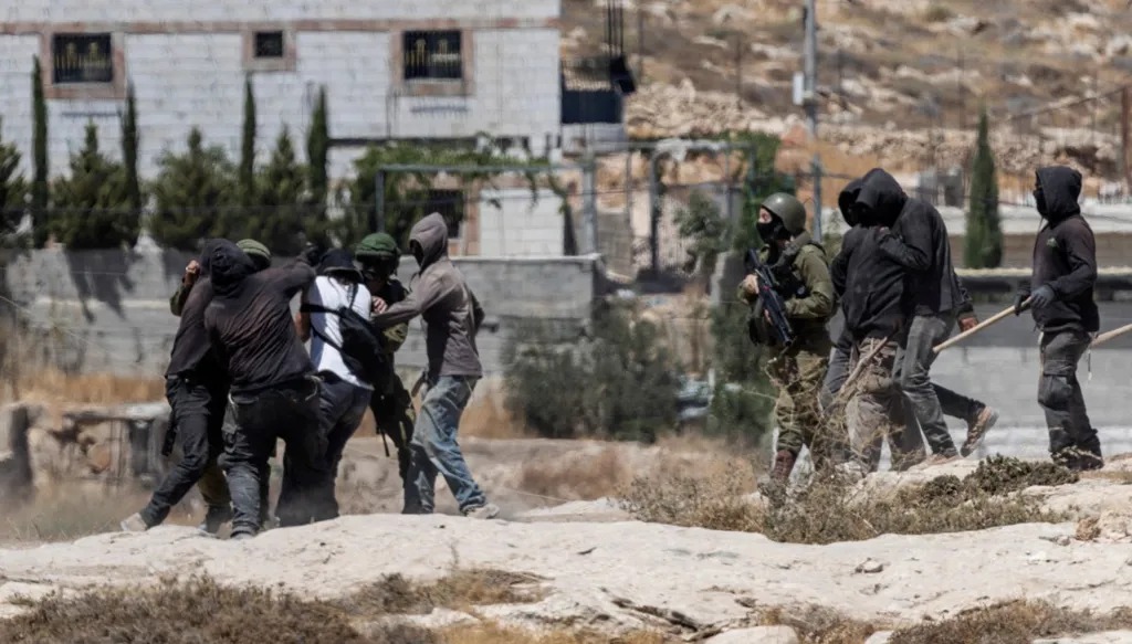 مستوطنون إسرائيليون يشتبكون مع نشطاء يساريين في وقت تدخل فيه قوات الجيش الإسرائيلي في بؤرة استيطانية إسرائيلية بقرية جنة الفلسطينية الخاضعة للاحتلال الإسرائيلي 25 أغسطس 2026. (أ ف ب)