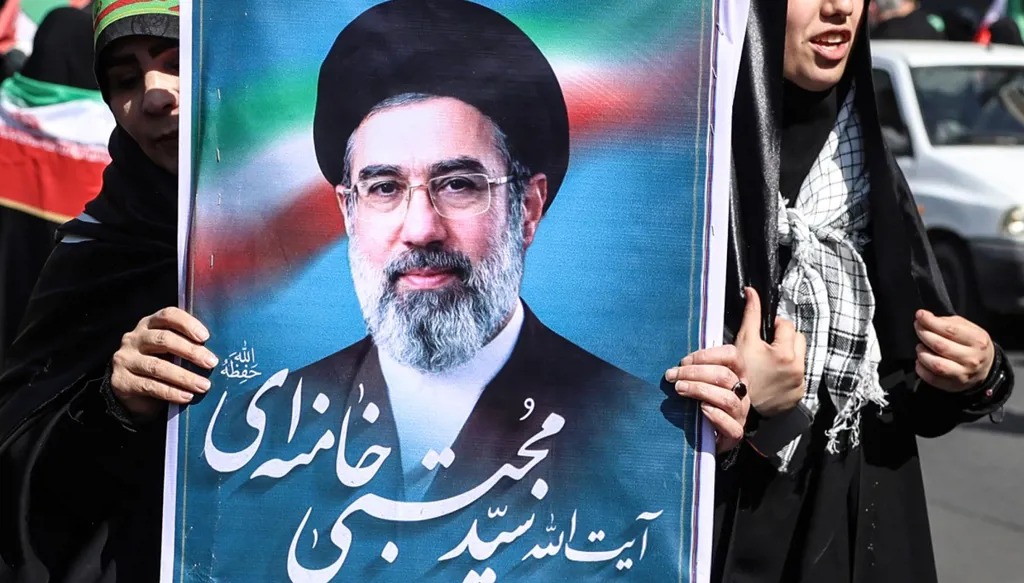 سيّدة إيرانية ترفع صورة المرشد الأعلى للجمهورية الإسلامية مجتبى خامنئي خلال تجمّع في طهران. (أ ف ب)