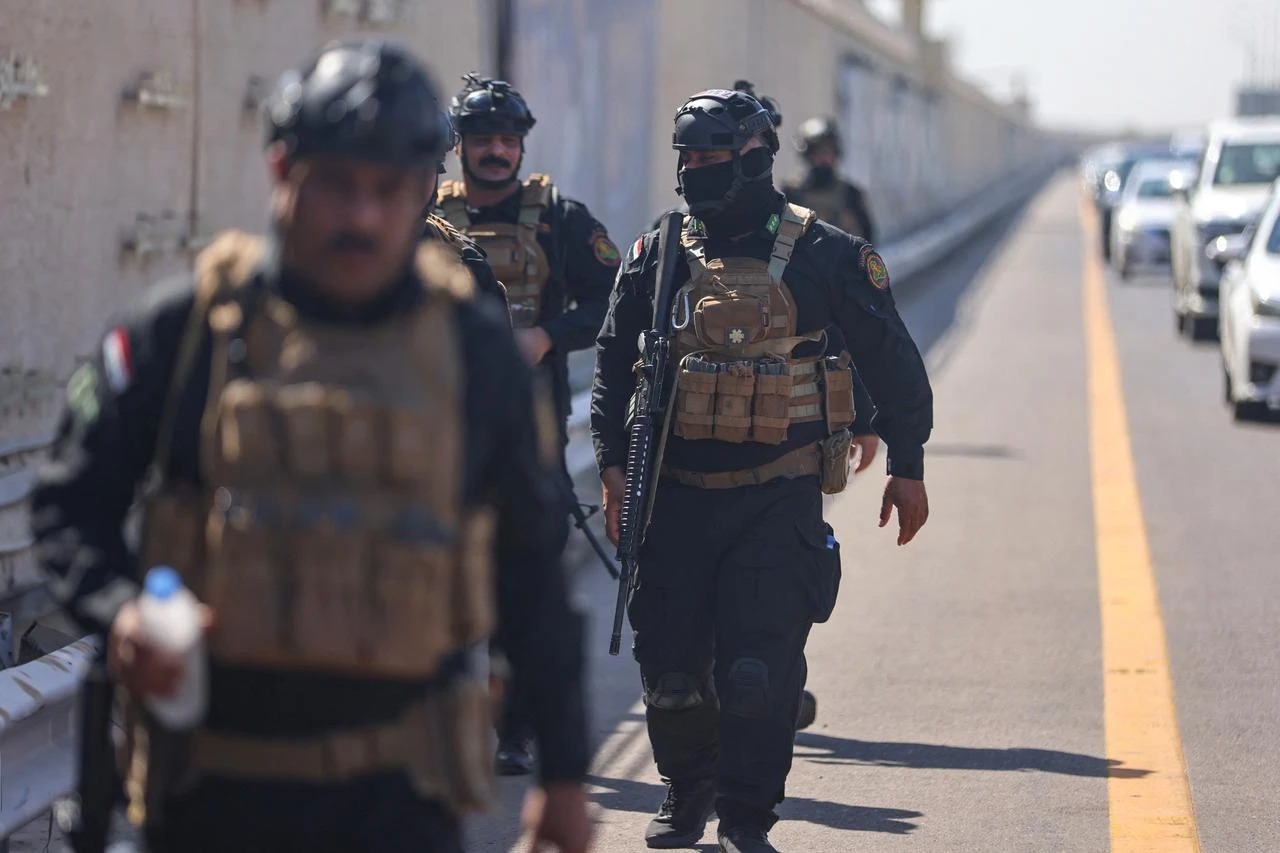 أفراد من القوات الخاصة العراقية ينتشرون على طريق مطار بغداد الدولي خلال وصول رئيس البرلمان الإيراني محمد باقر قاليباف إلى بغداد، 19 آب/ أغسطس 2026 (أ ف ب).