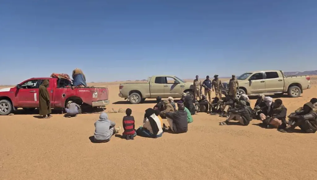 مهاجرون أوقفتهم دوريات جهاز مكافحة الهجرة غير الشرعية في الصحراء قرب الحدود الليبية–السودانية، ضمن عملية أحبطت تهريب مهاجرين ووقود في آذار/مارس 2026. (جهاز مكافحة الهجرة غير الشرعية الليبي)