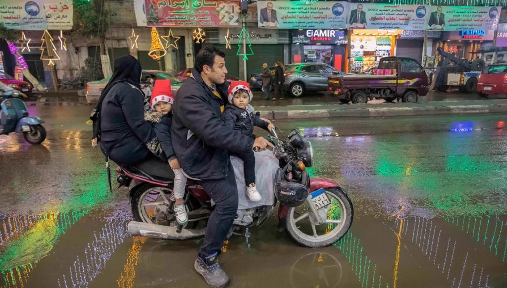 عائلة تنتقل على دراجة نارية في حي شبرا القاهرة (أ ف ب)