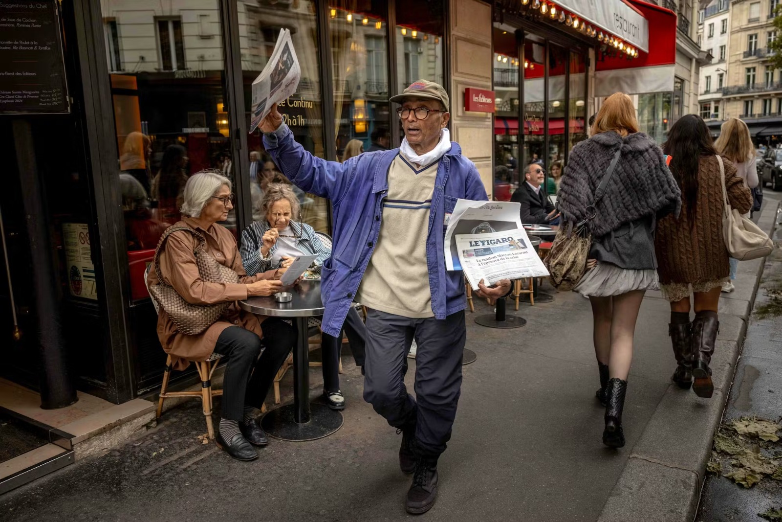 آخر بائع صحف ينادي بالعناوين في شوارع باريس. (أ ف ب)