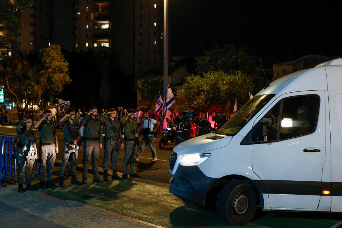جنود إسرائيليون يؤدون التحية العسكرية عند وصول مركبات تنقل جثث ‏أسرى تم تسليمهم في أعقاب صفقة التبادل (أ ف ب)‏