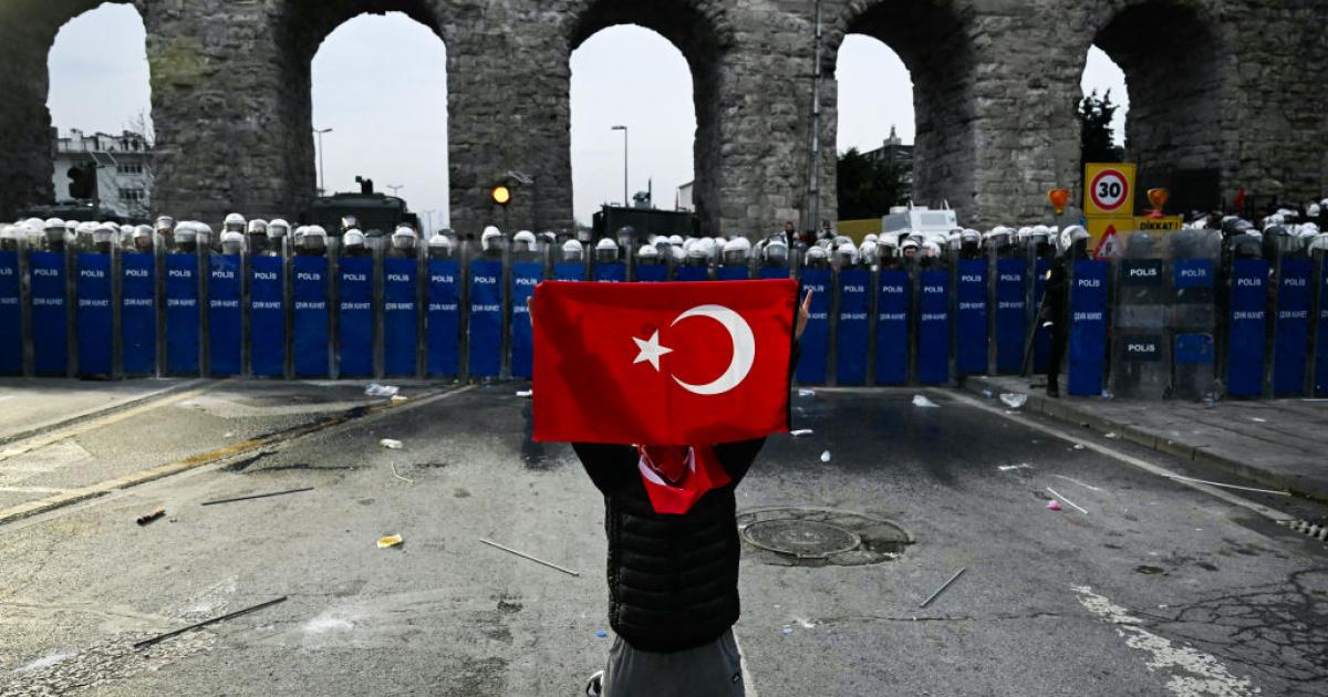 تركي بمواجهة عناصر مكافحة الشغب خلال احتجاجات اسطنبول (غيتي)